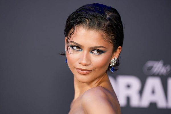 Zendaya poses on the red carpet in a wetlook bixie hairstyle and blue eyeshadow.